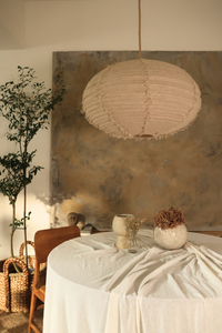 Dining area with a table, chairs, and decorative items against a textured wall.