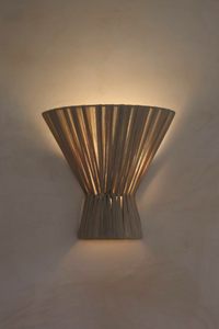 Decorative wall sconce with a ribbed design on a light-colored wall.