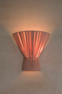 Blush pink wall sconce on a beige wall