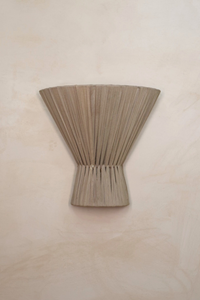 A handcrafted cloth wall lighting sconce with a textured surface and a clay color, designed to provide soft, ambient light.