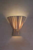 Decorative wall sconce casting a warm glow on a textured wall.