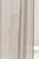 Sheer beige curtain with a blurred background
