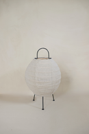 A Desa linen table lamp with a natural rattan body and a white linen shade, standing on a minimalist tripod base.