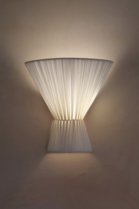 Wall-mounted light fixture with pleated design on a plain wall